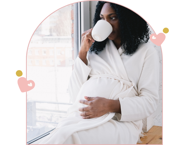 Femme enceinte en peignoir buvant dans une tasse